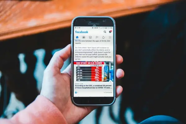 hand-holding-a-phone-facebook-app-post-on-the-screen
